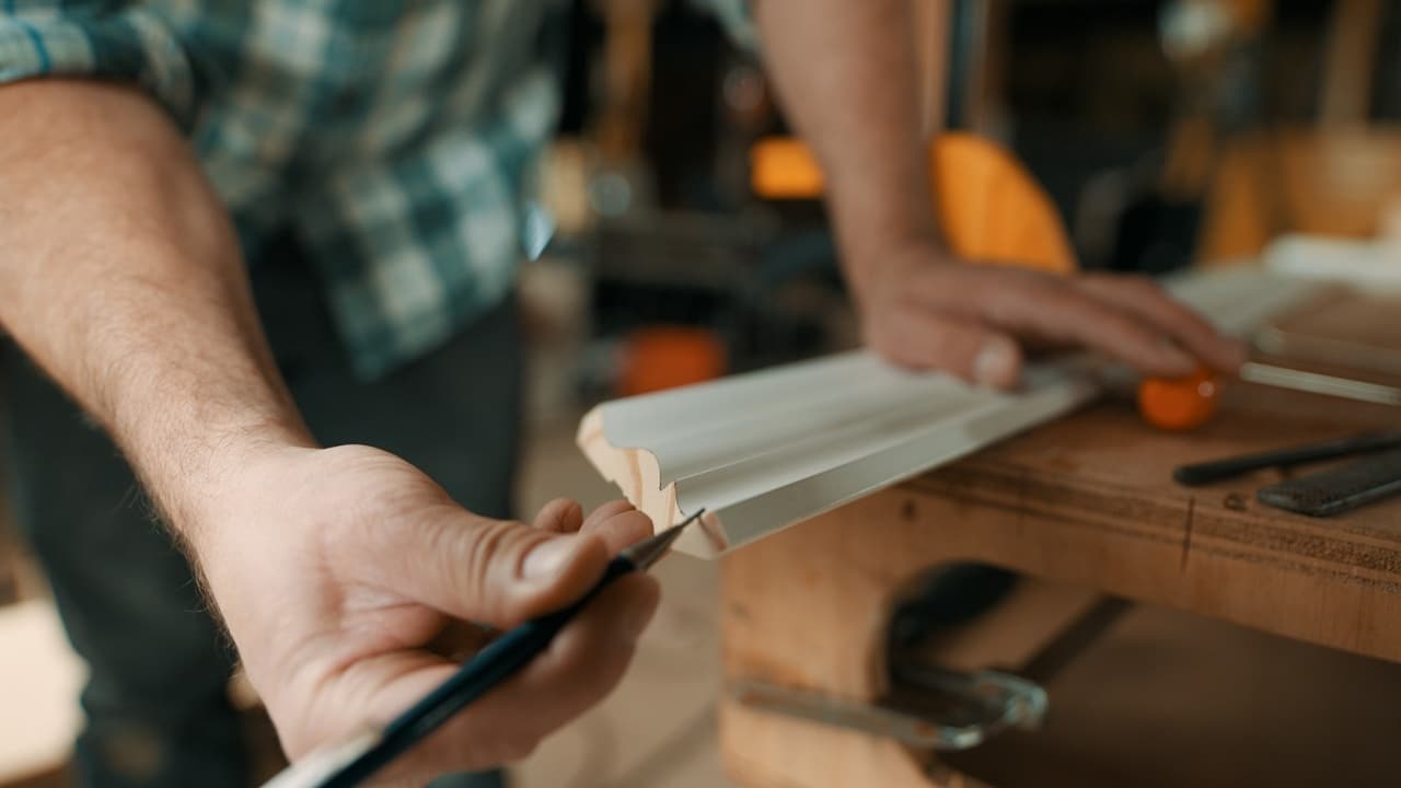 Person darkening the profile of the leading edge on a cut piece of moulding