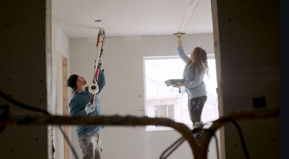 Two contractors mudding and taping a drywall ceiling