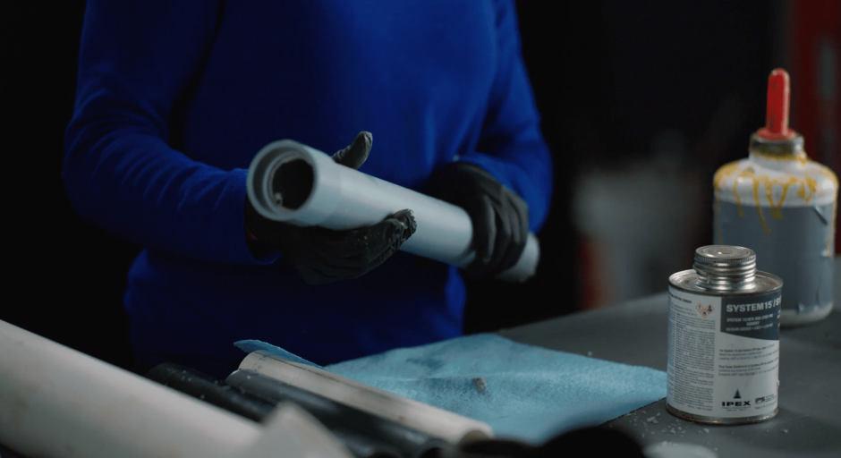 Plumber holds a piece of PVC pipe