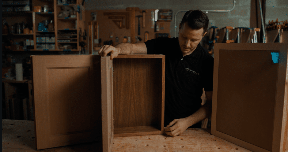 Cabinet maker holds open a frameless cabinet