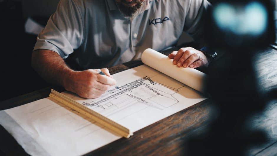 Architect working on design plans at desk