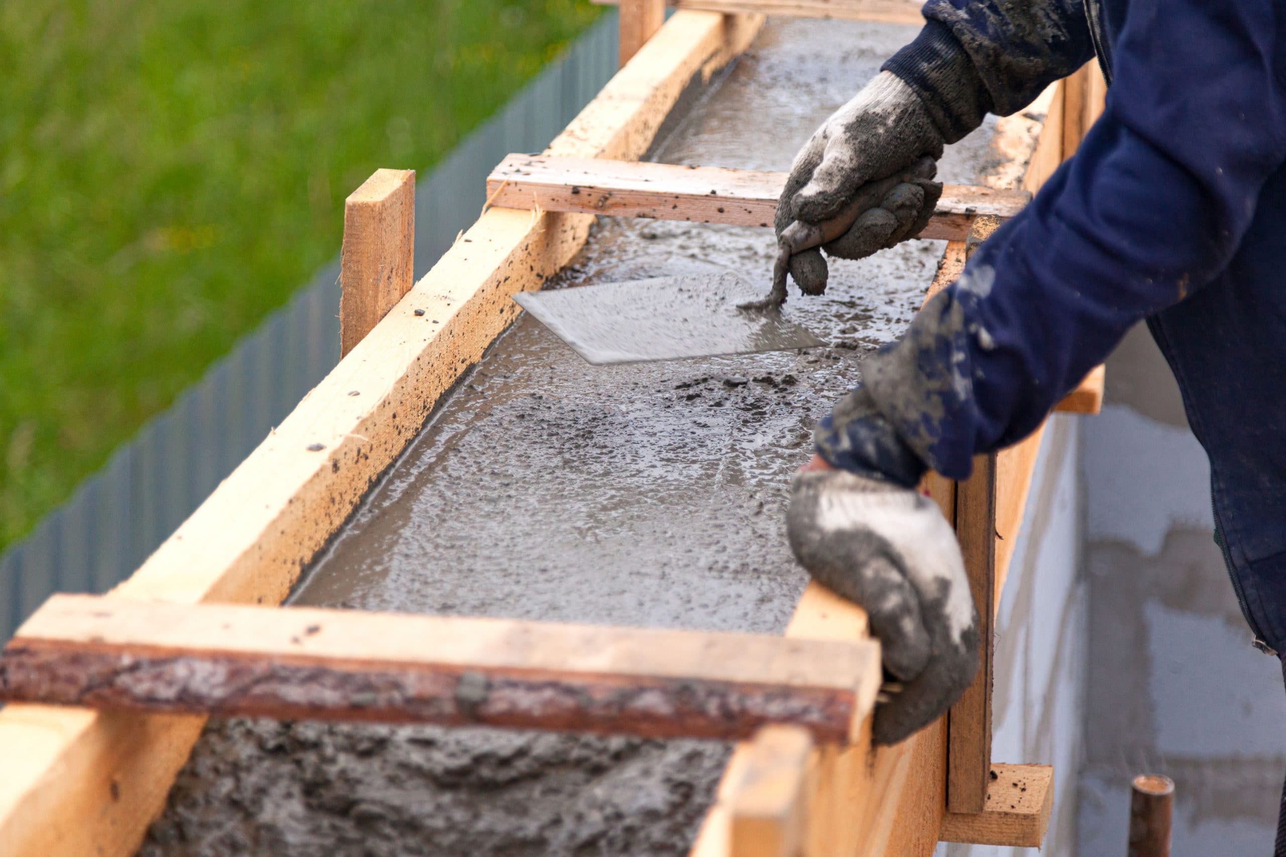 Worker levels concrete in formwork using a trowel