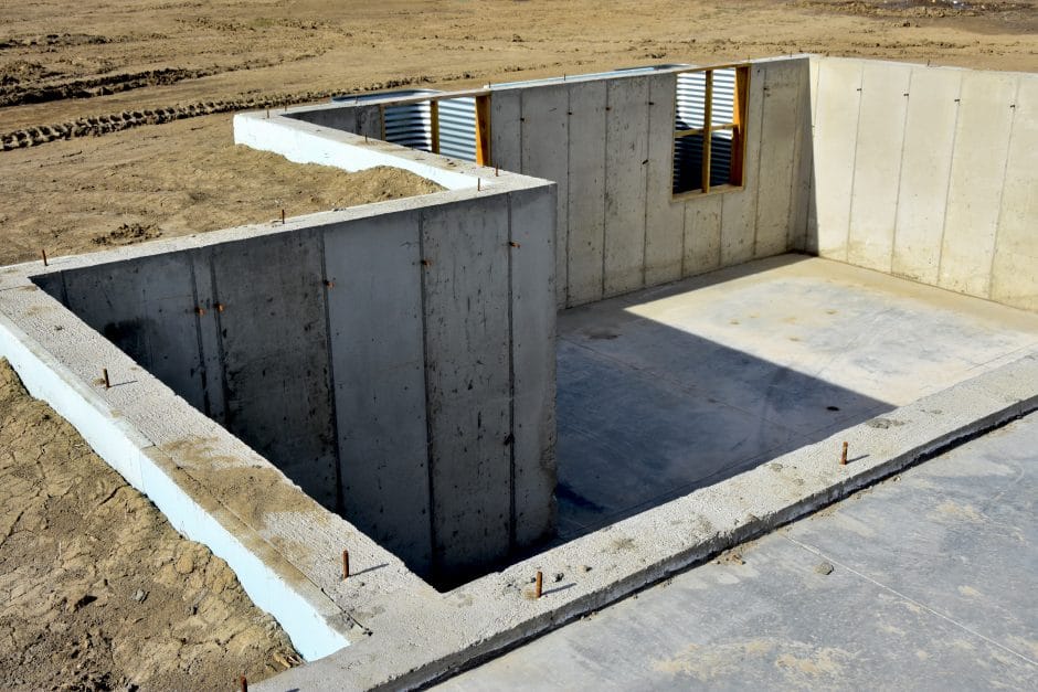 Concrete slab and walls of basement ready for lumber.