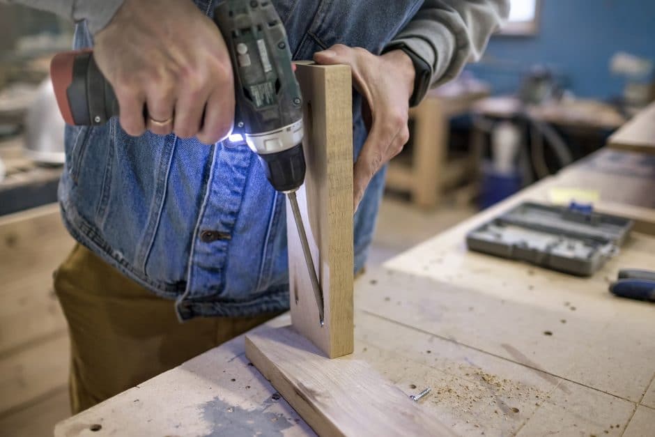 carpenter installs the furniture hinge with pocket hole joinery concept.