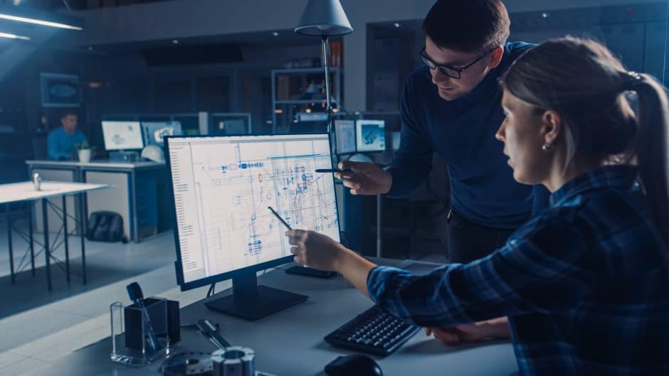 Engineer Working on Desktop Computer, Screen Showing CAD Software with Technical Blueprints