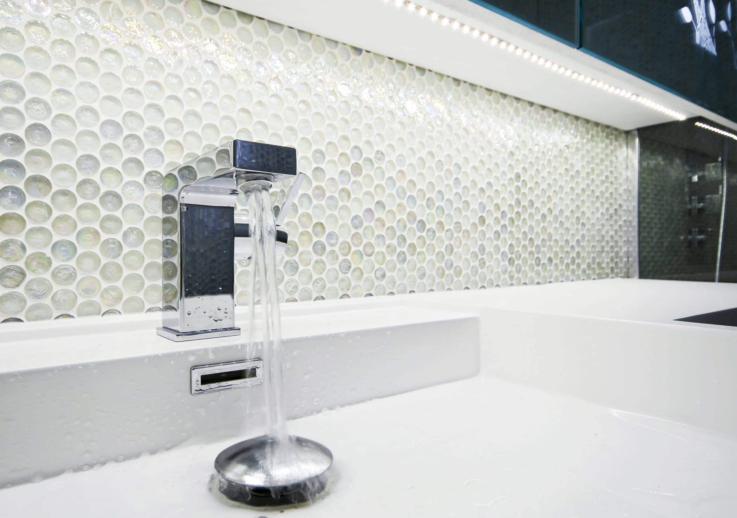 Bathroom with glass mosaic tile backsplash.