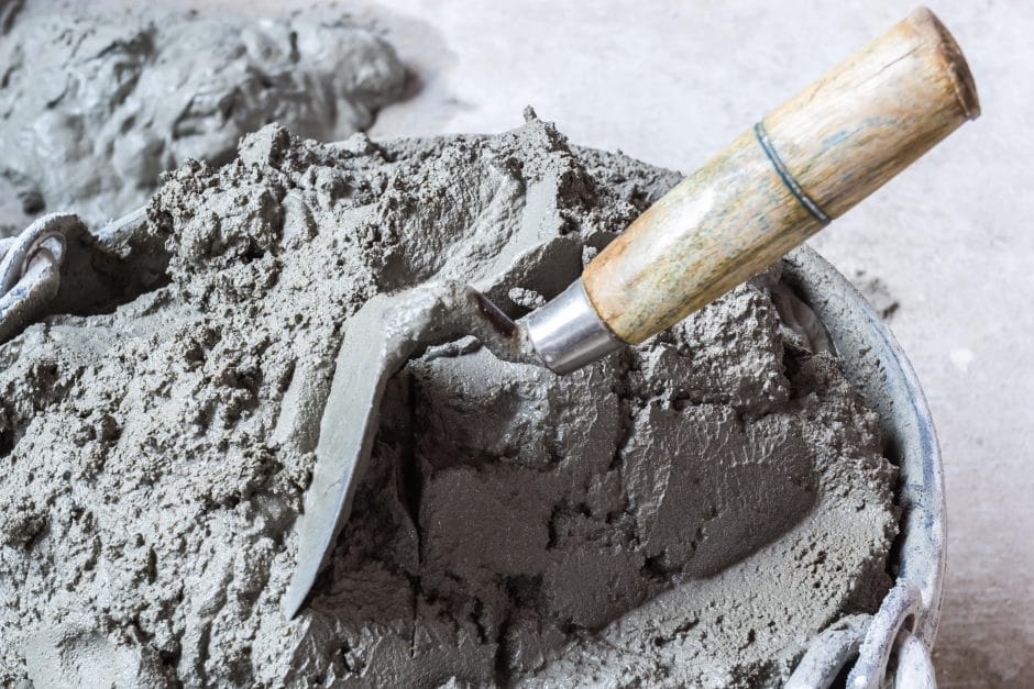 Concrete being mixed in bucket with trowel