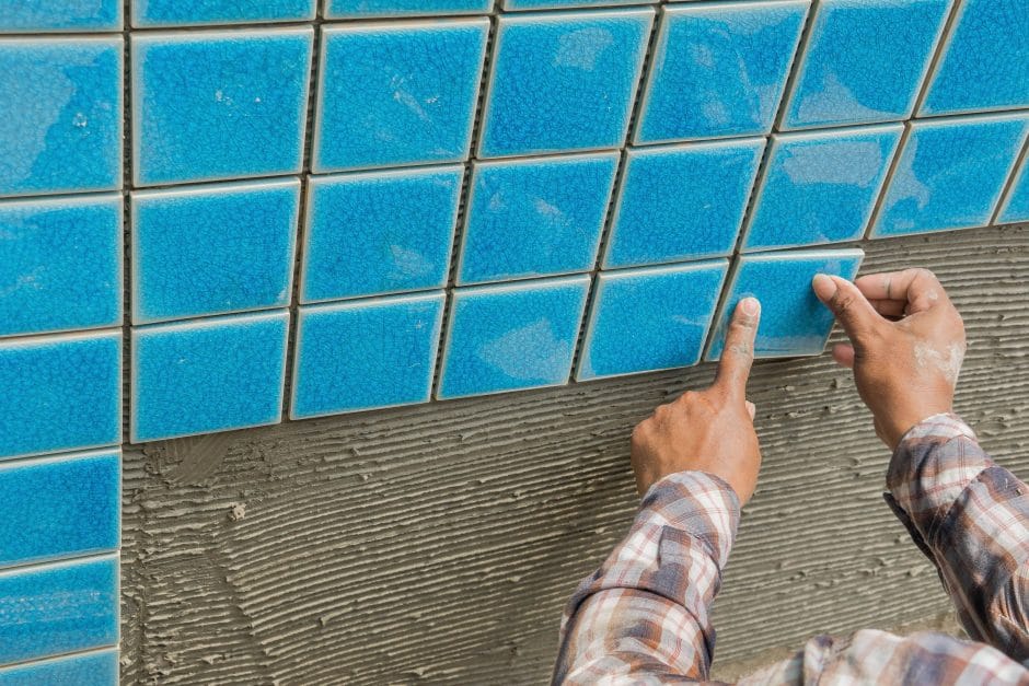 Professional tiler tiling a pool